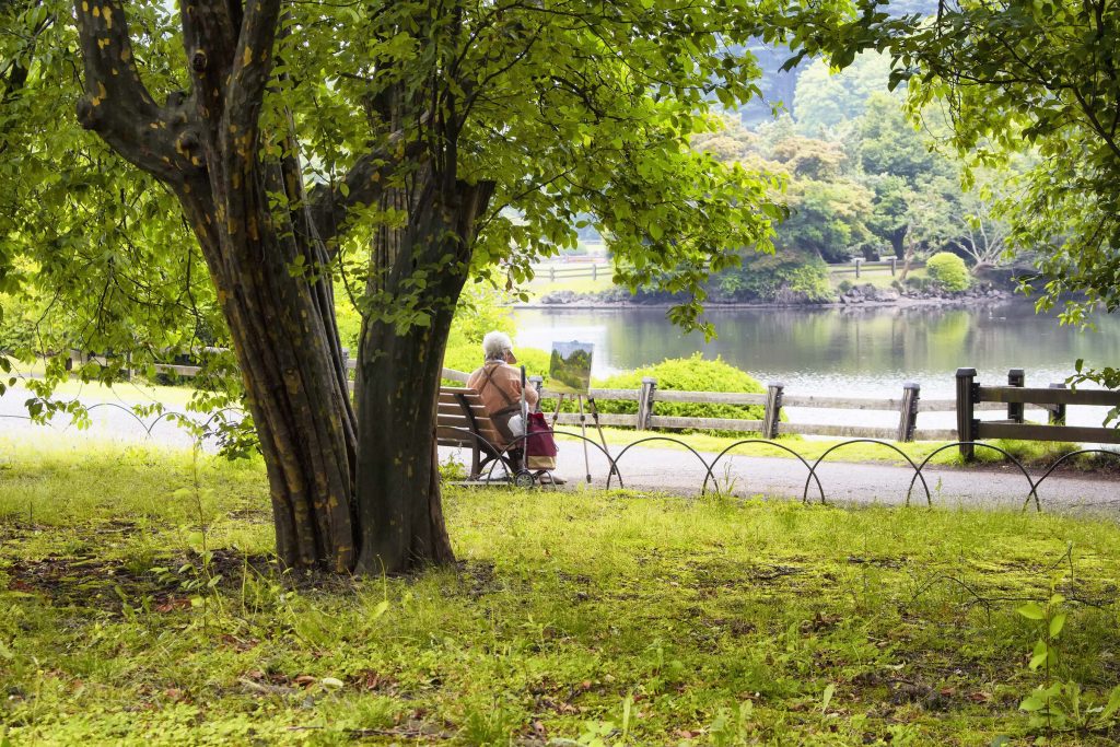 Tokyo, Japan - May 28, 2016: Old woman paints at Shinjuku garden